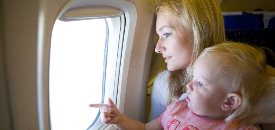 Baby and parent on airplane looking out window