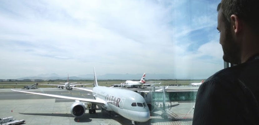 Brian looking at a Qatar Airways plane