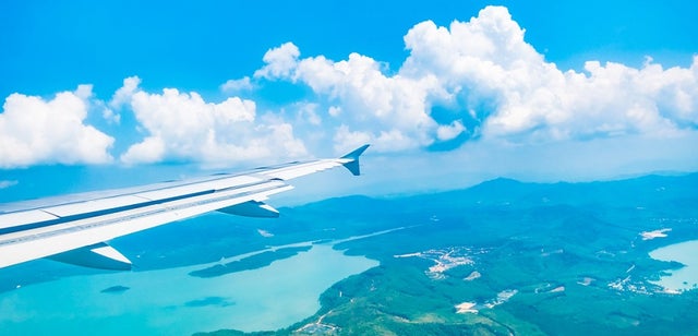 IMG Airplane wing tip island sky featured shutterstock 416971021