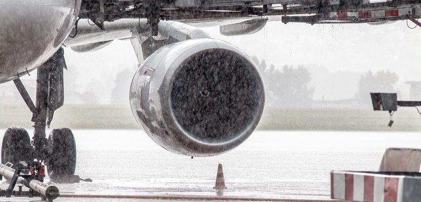 Cropped Image Of Airplane On Runway During Rainfall
