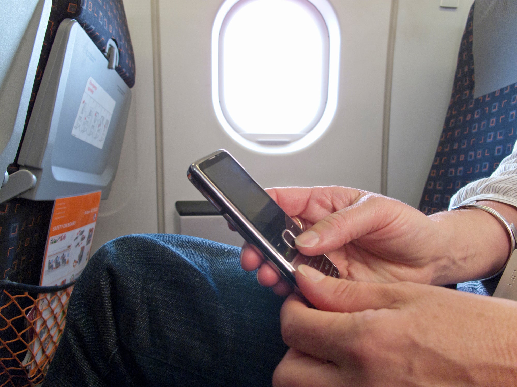A person using a phone on a plane