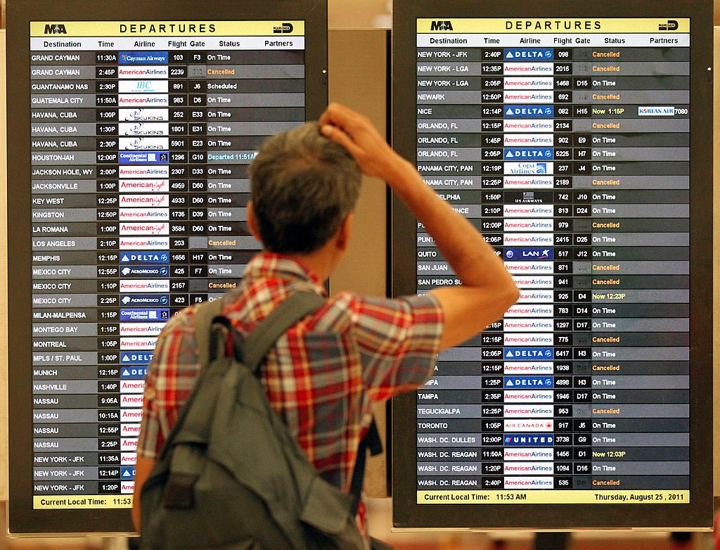 Sanjay Roy, of Miami, checks the departure board as flights at Miami International Airport are canceled due to Hurricane Irene, Thursday, August 25, 2011.
