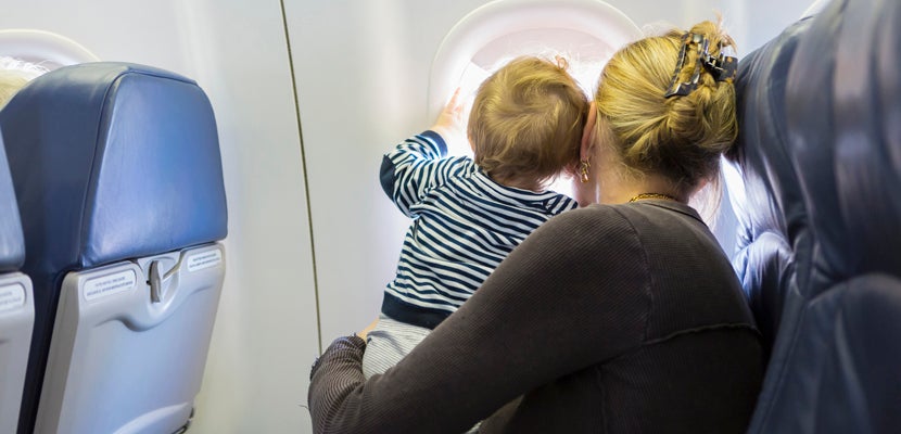 Mother and baby looking out airplane window