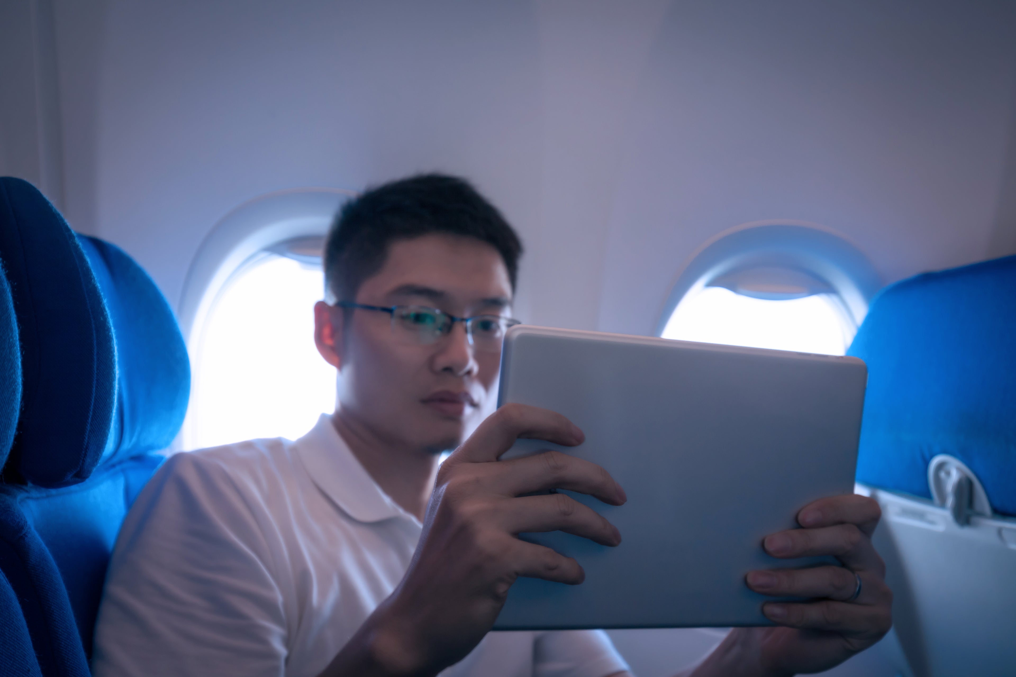 Businessman using digital tablet in airplane travelling