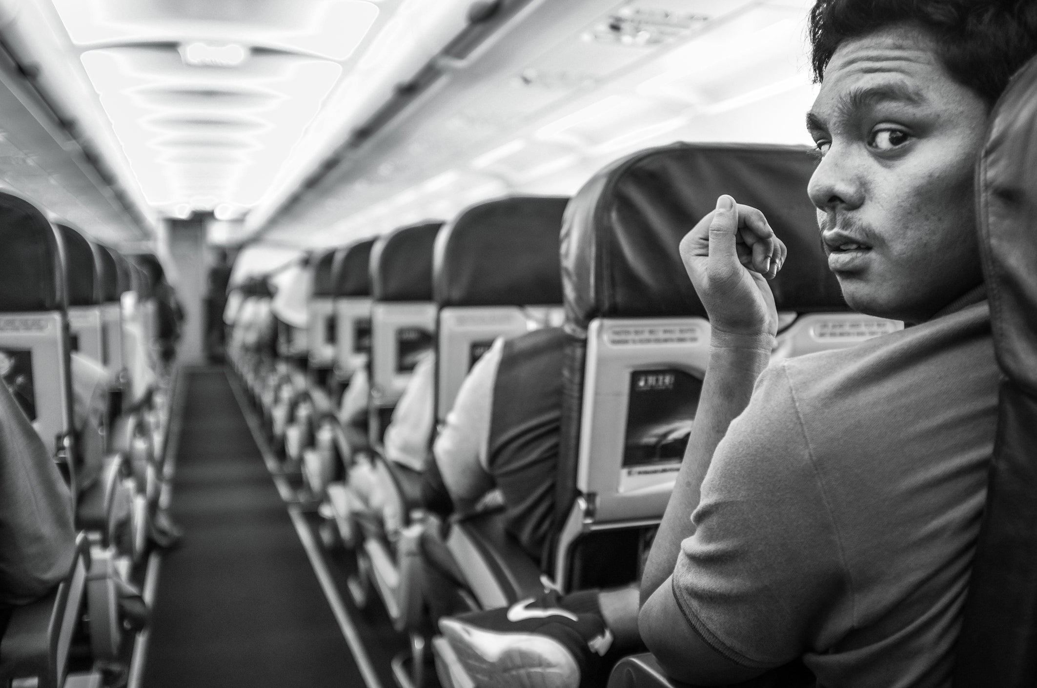 Rear View Portrait Of Young Man Sitting In Airplane