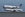 A United 747-400 lands while a Singapore Airlines A350 taxies to takeoff.