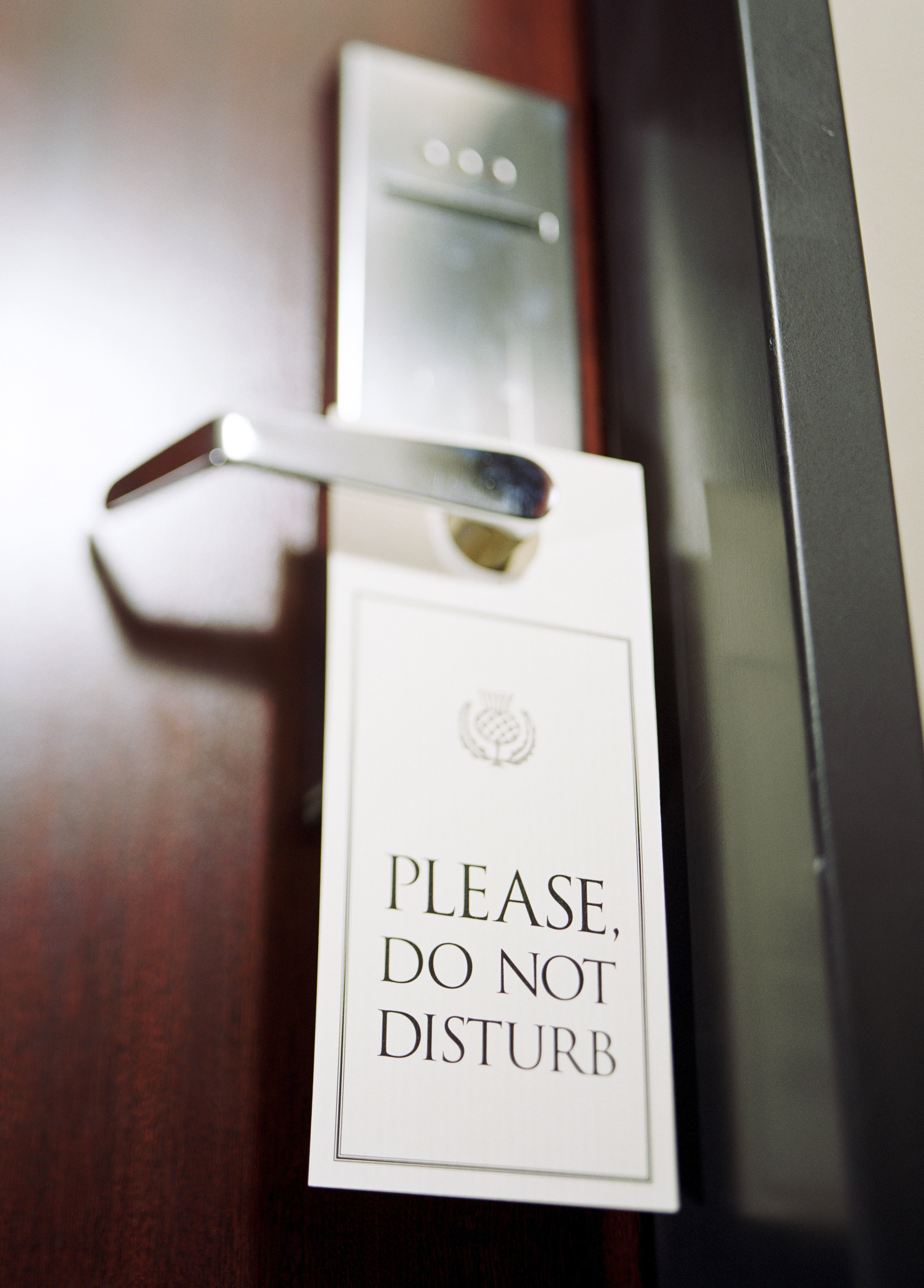Do not disturb sign hanging from hotel door handle (selective focus)