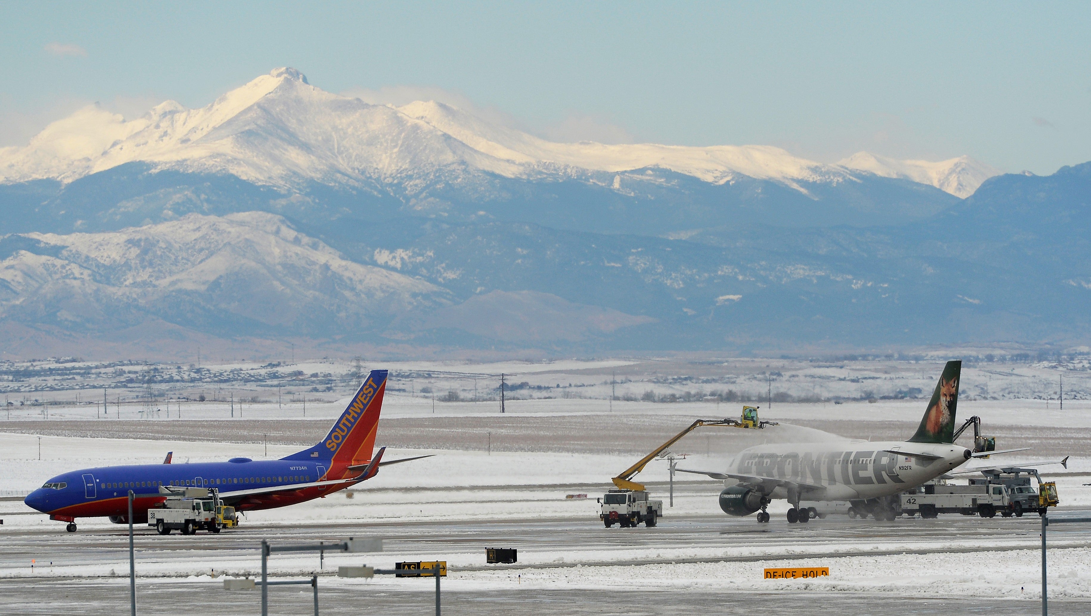 Planes on a snow-covered runway at Denver's airport