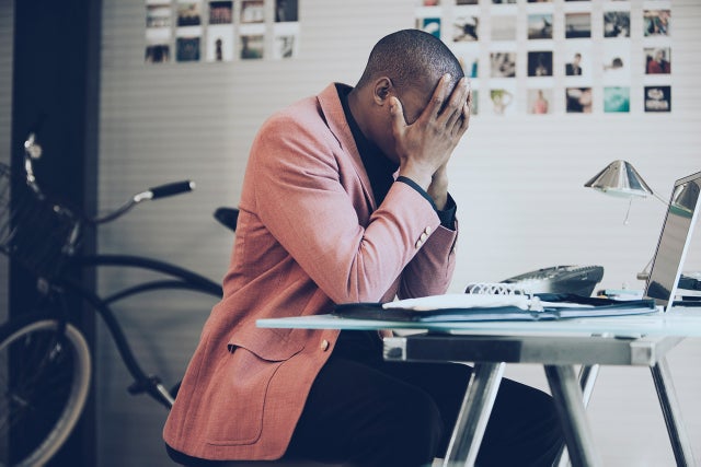 Frustrated African American businessman sitting at desk