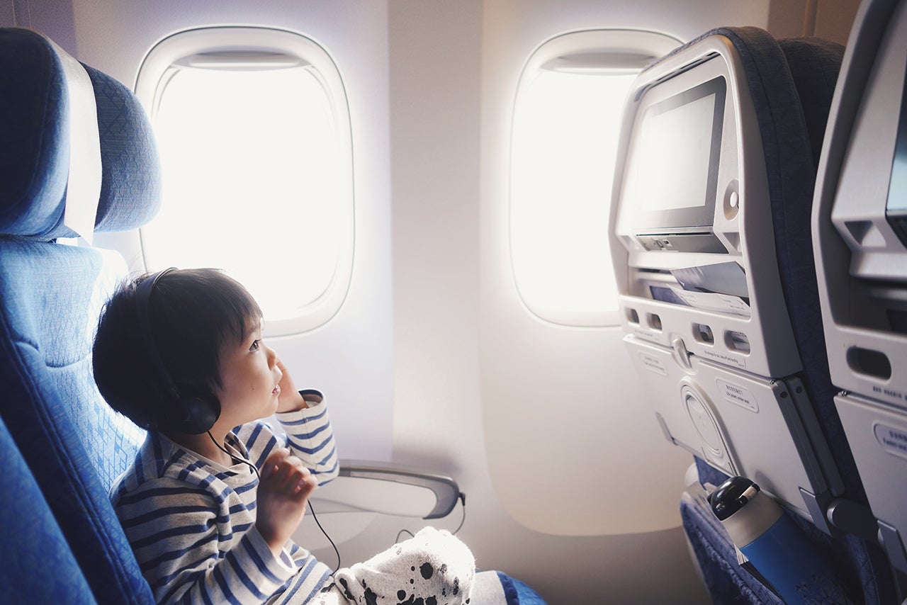 Side View Of Boy Sitting In Airplane