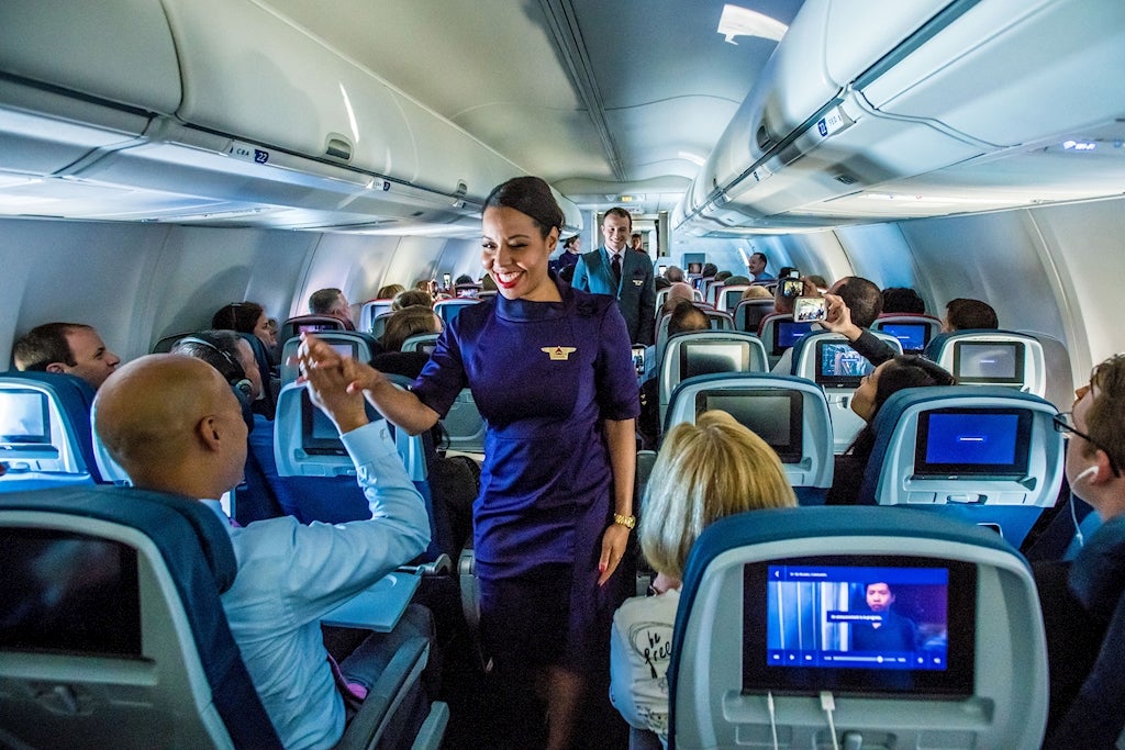 Flight attendant employee model launches uniform during mid-flight fashion show