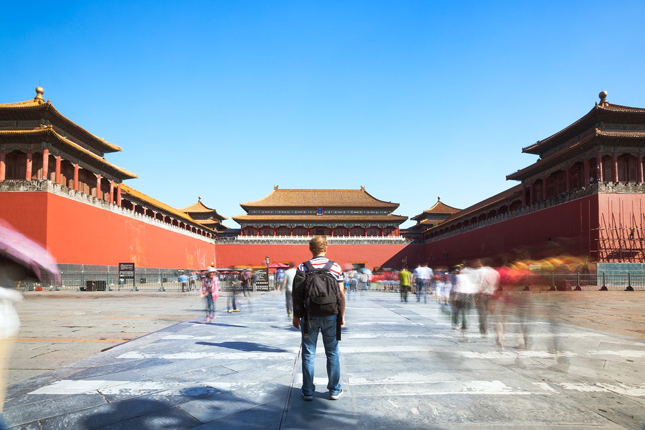Tourist looking at the Forbidden city in Beijing in a sunny day