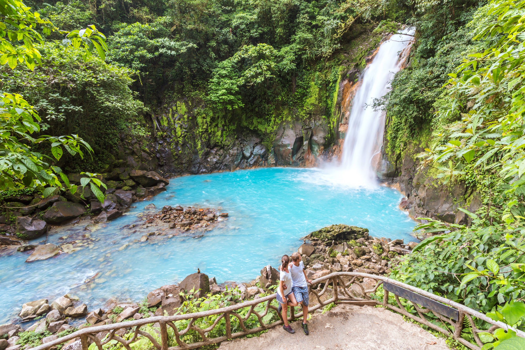 Tourist couple looking at Rio Celeste waterfall