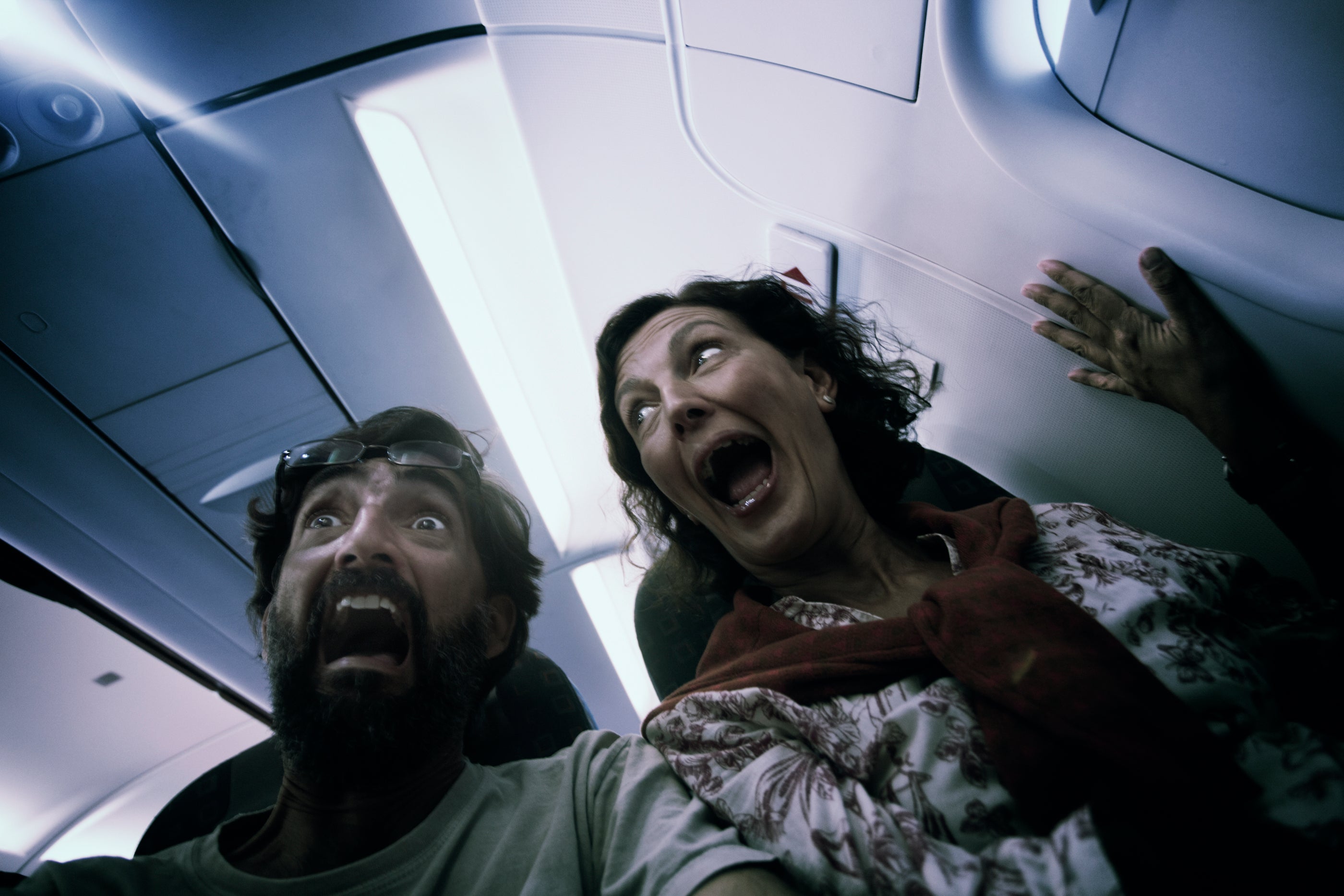 Middle aged couple in terror on a plane.