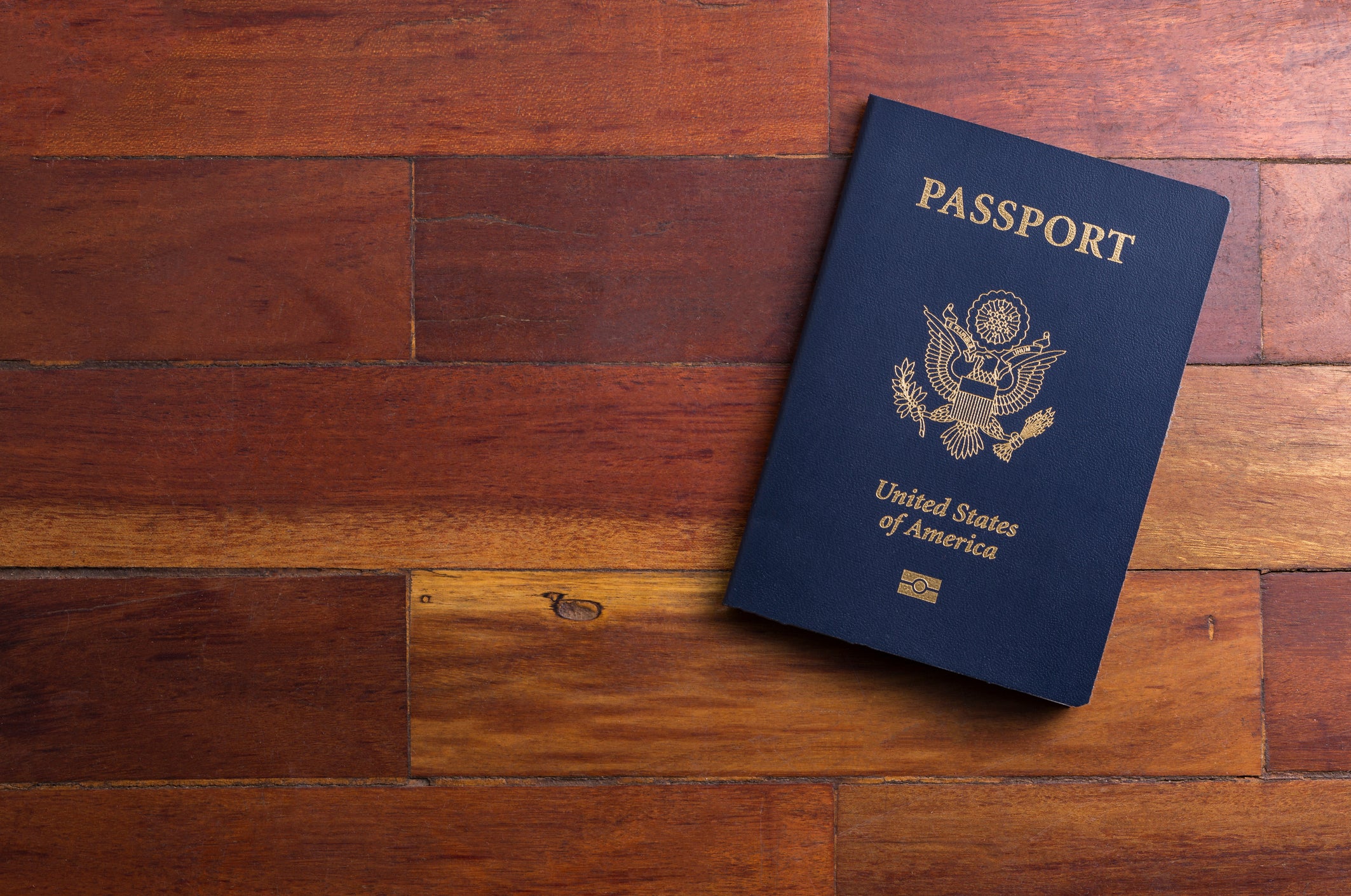 Close-Up Of Passport On Wooden Table