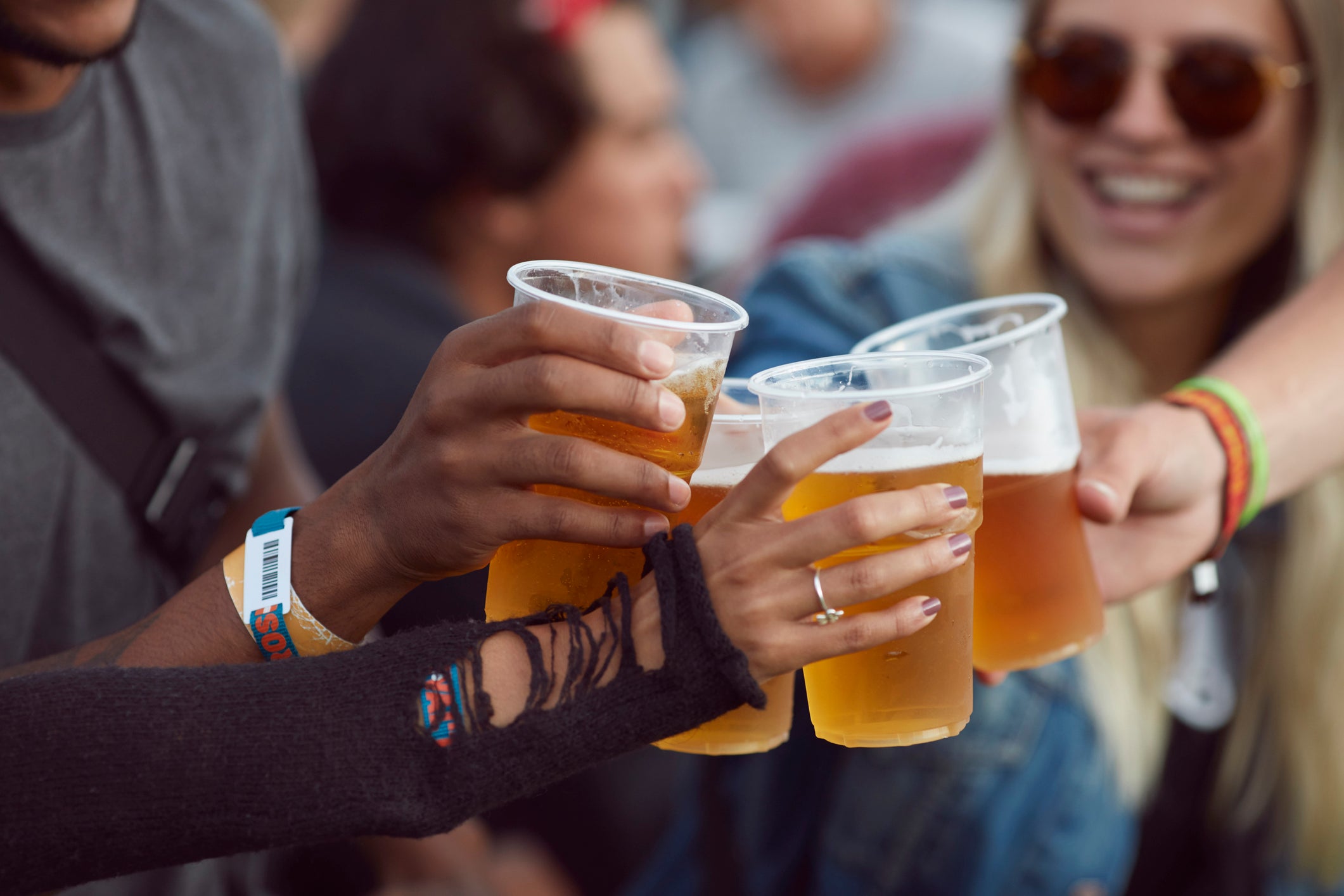 Close-up uf hands toasting in beer, at festival