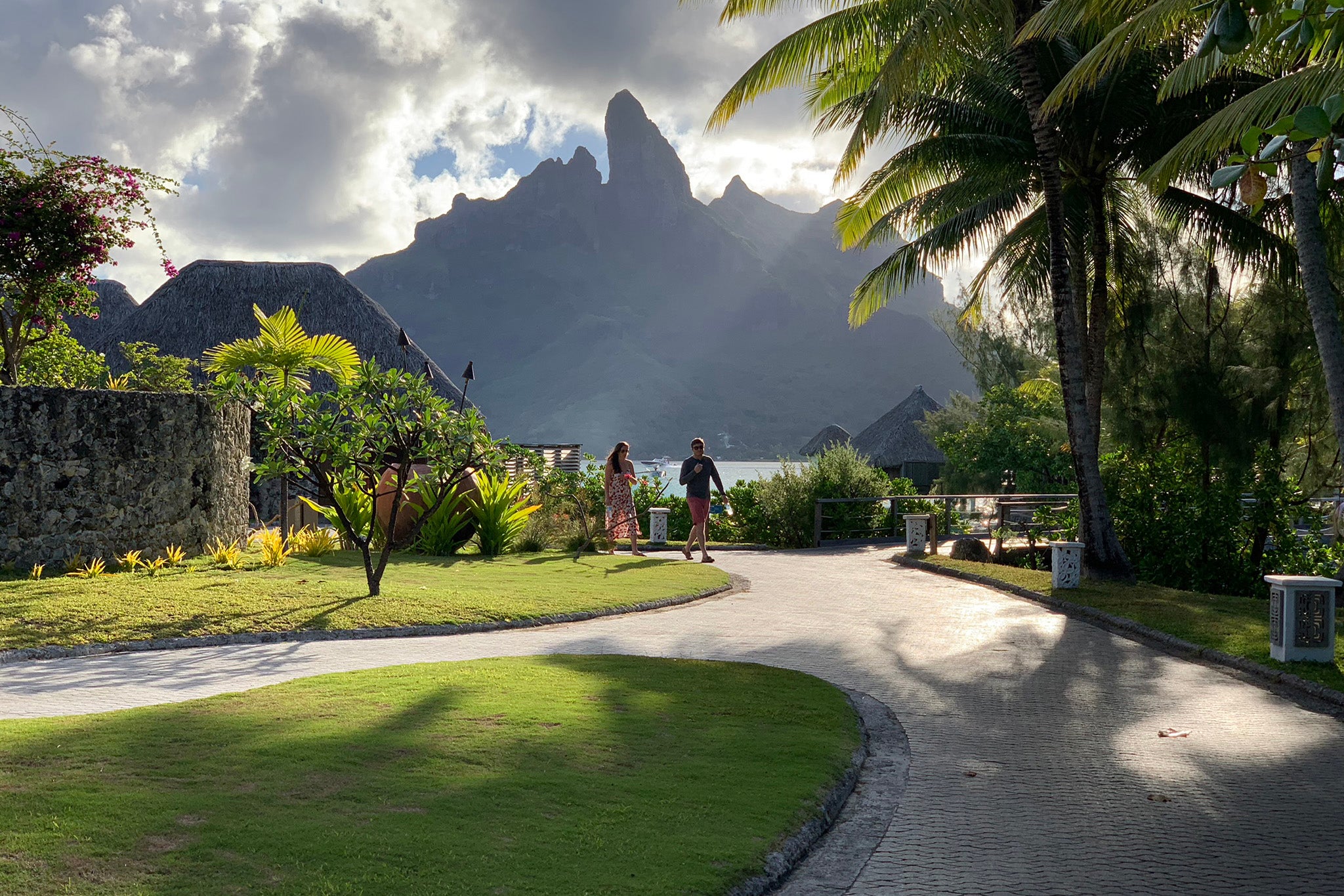 people walk on a garden path at a luxury hotel on an island