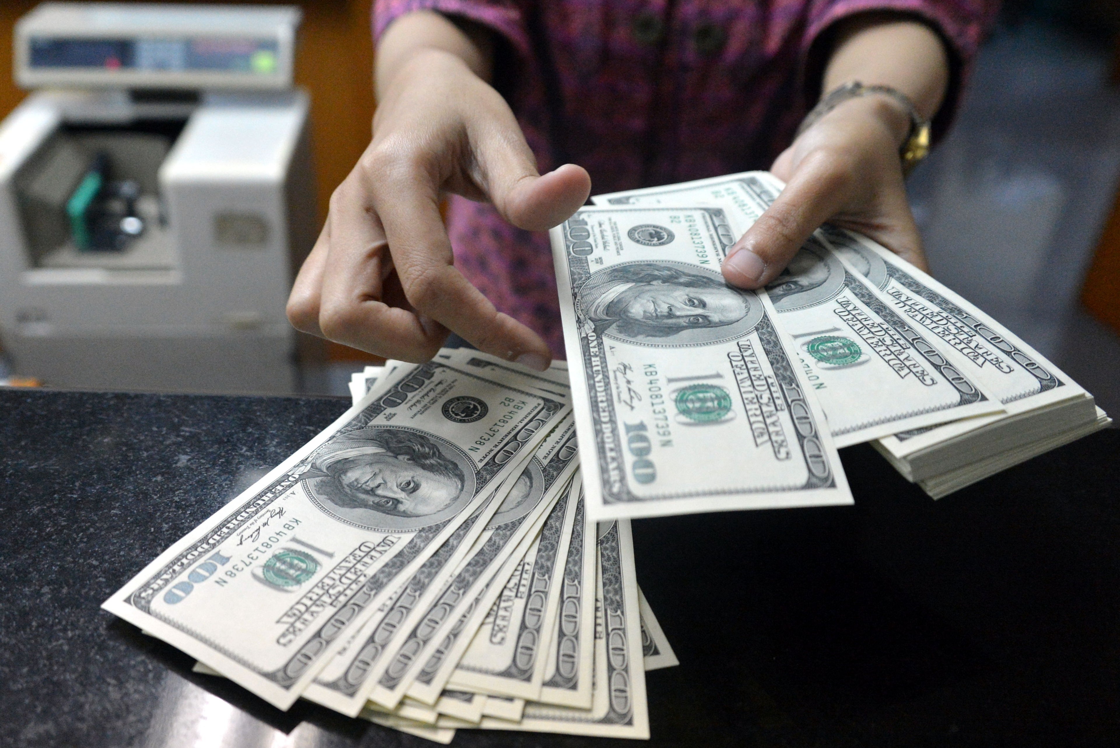 An employee counts USD notes at a money change outlet in Jakarta on June 14, 2013.