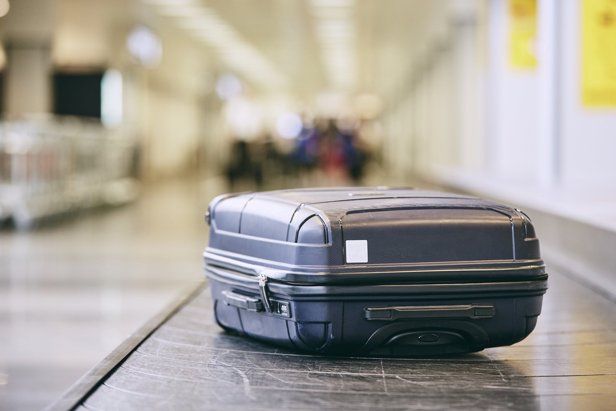 Close-Up Of Black Luggage Suitcase On Conveyor Belt At Airport