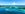 Palm trees and a sunny day in an idyllic beach with emerald water at Caribbean Nassau, Bahamas. Coral reef at crystal waters.