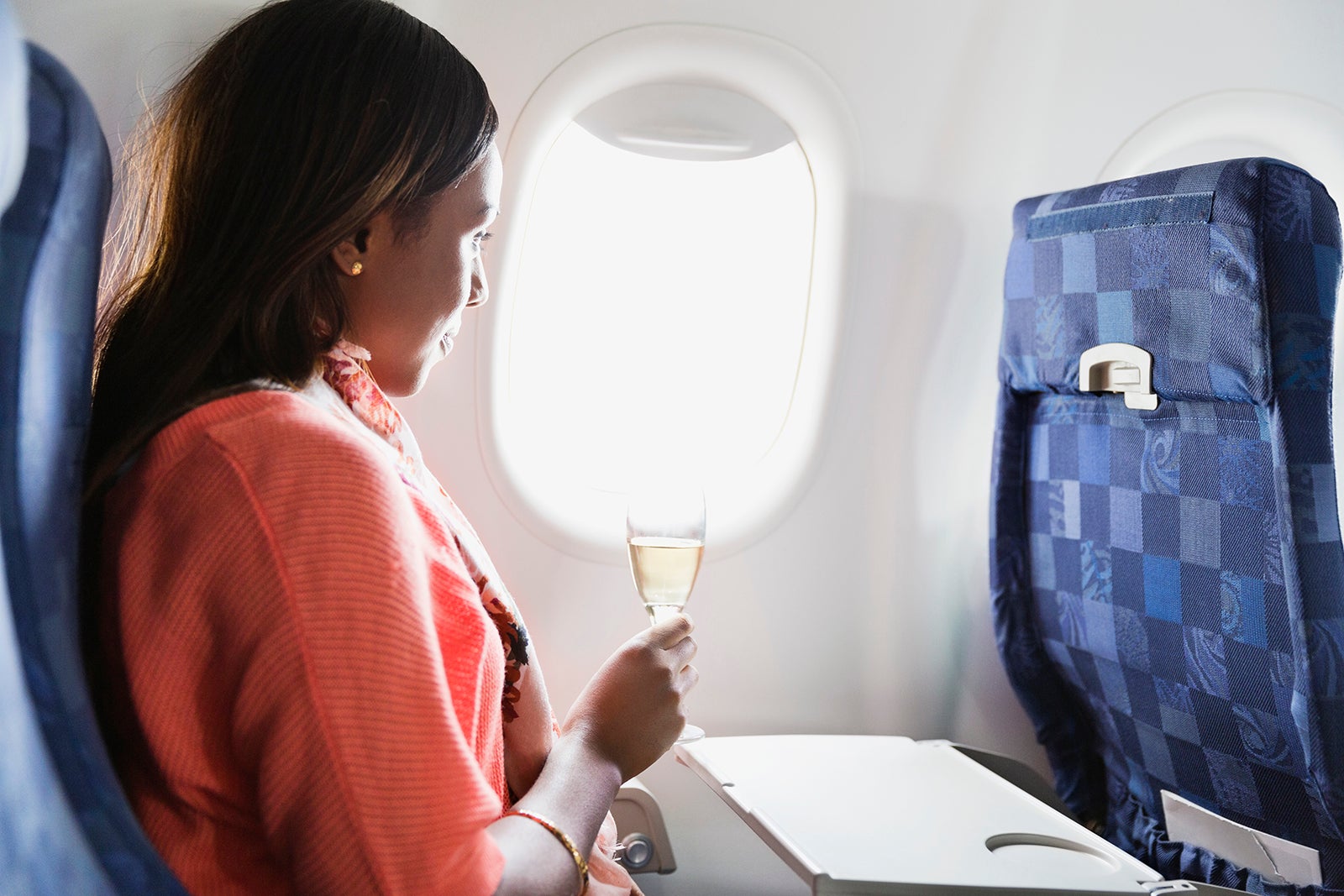 Woman relaxing with a drink in airplane