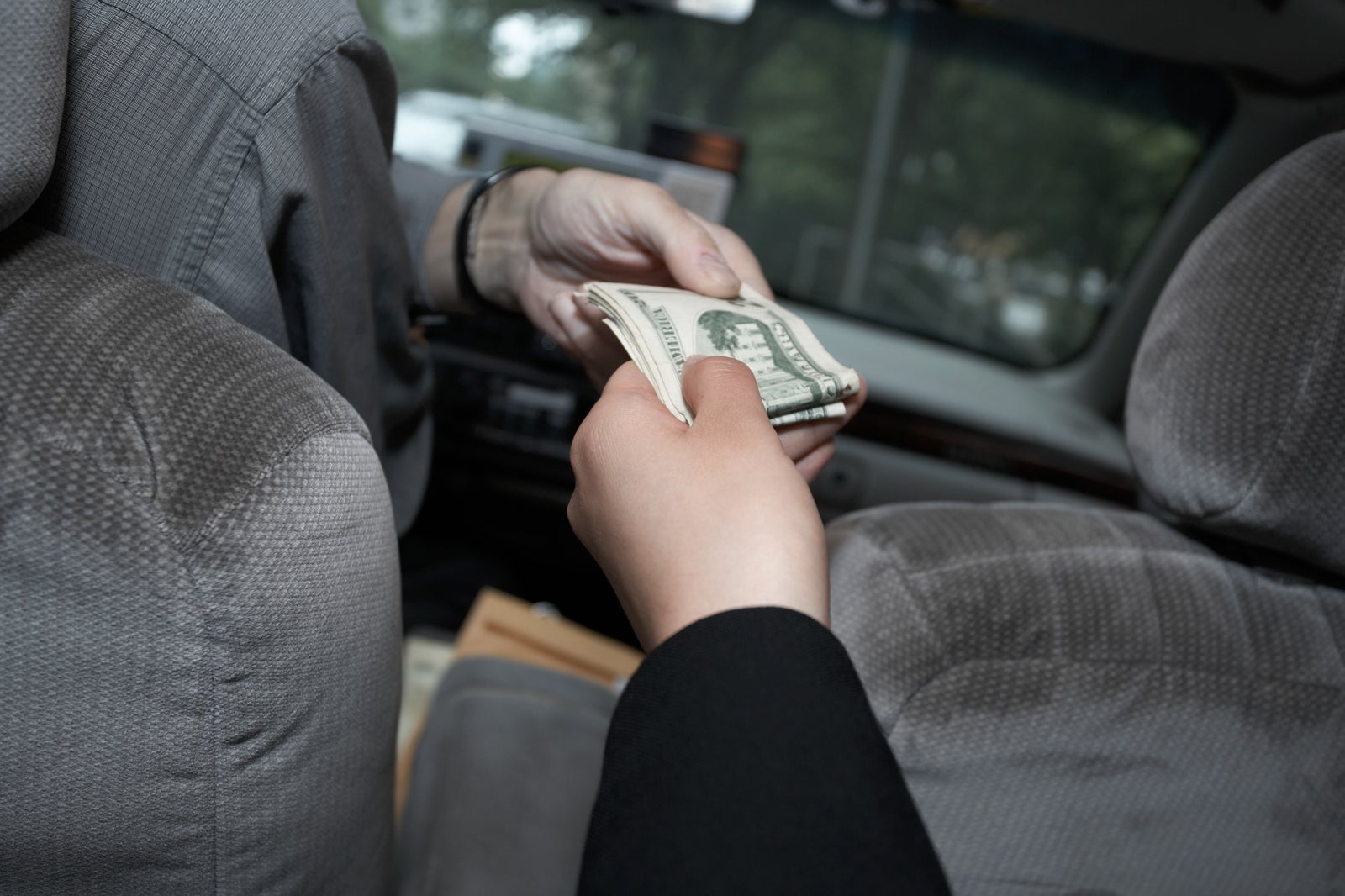 Businesswoman handing money to cab driver