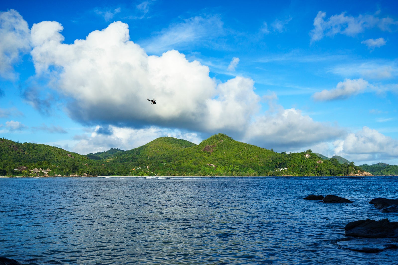 A helicopter flies over the Baie Lazare, Seychelles. (Photo via Getty Images)