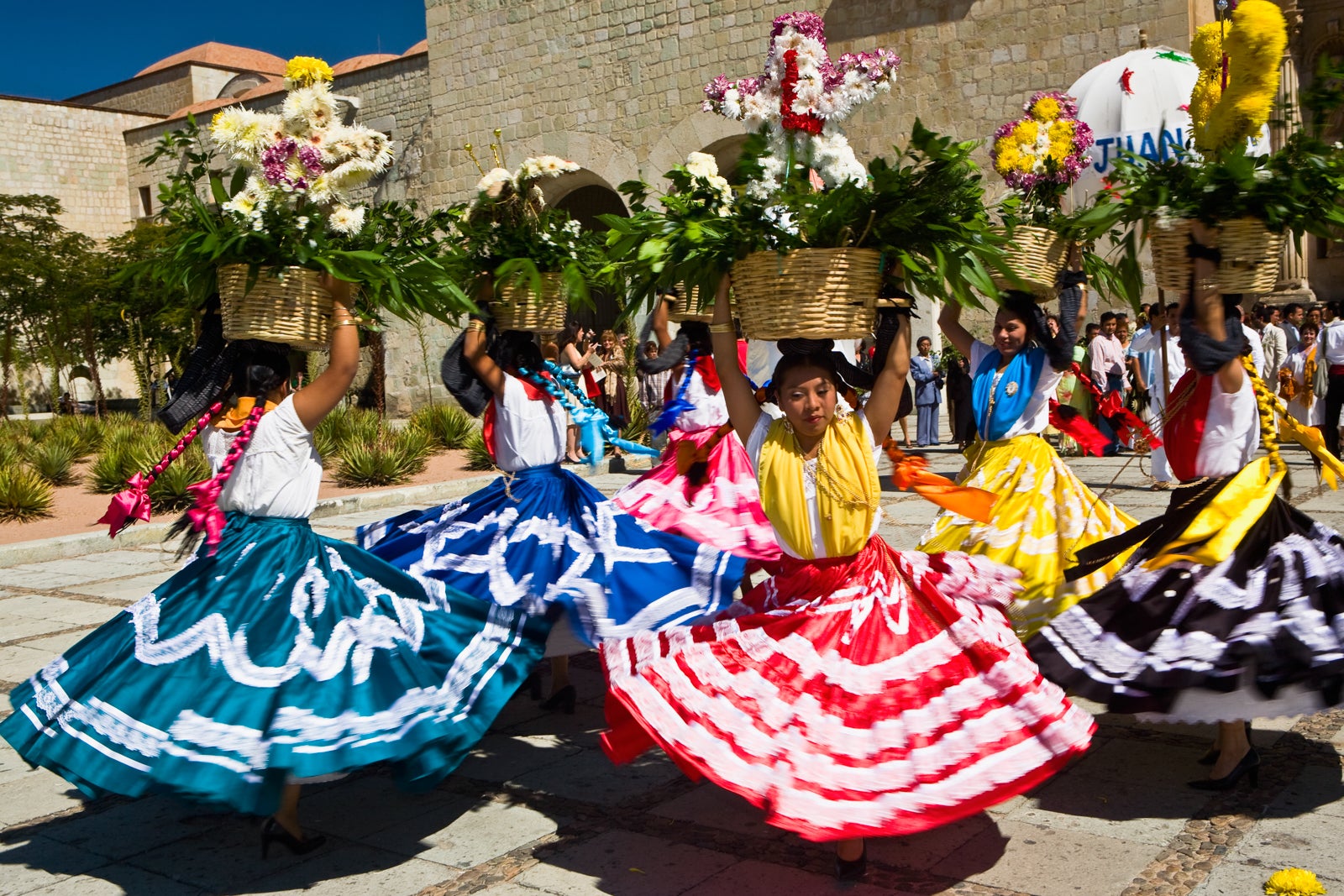 Female dancers dancing with potted plant over their head, Oaxaca, Oxaca State, Mexico