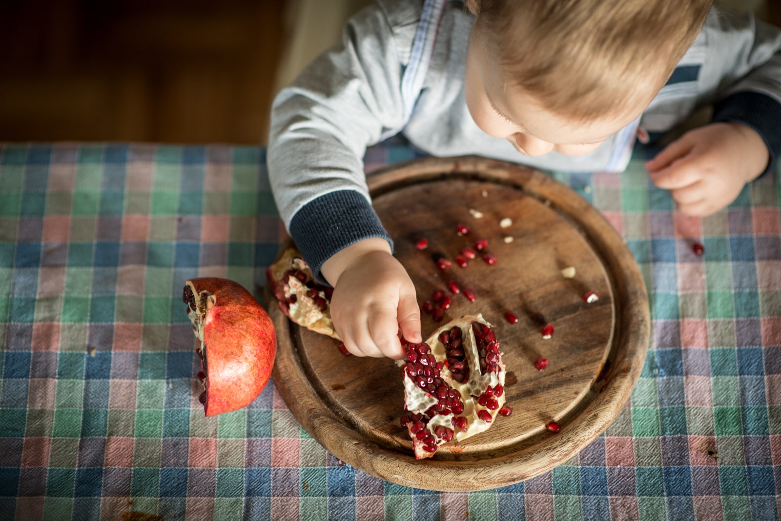 Baby eating a pomegranate fruit