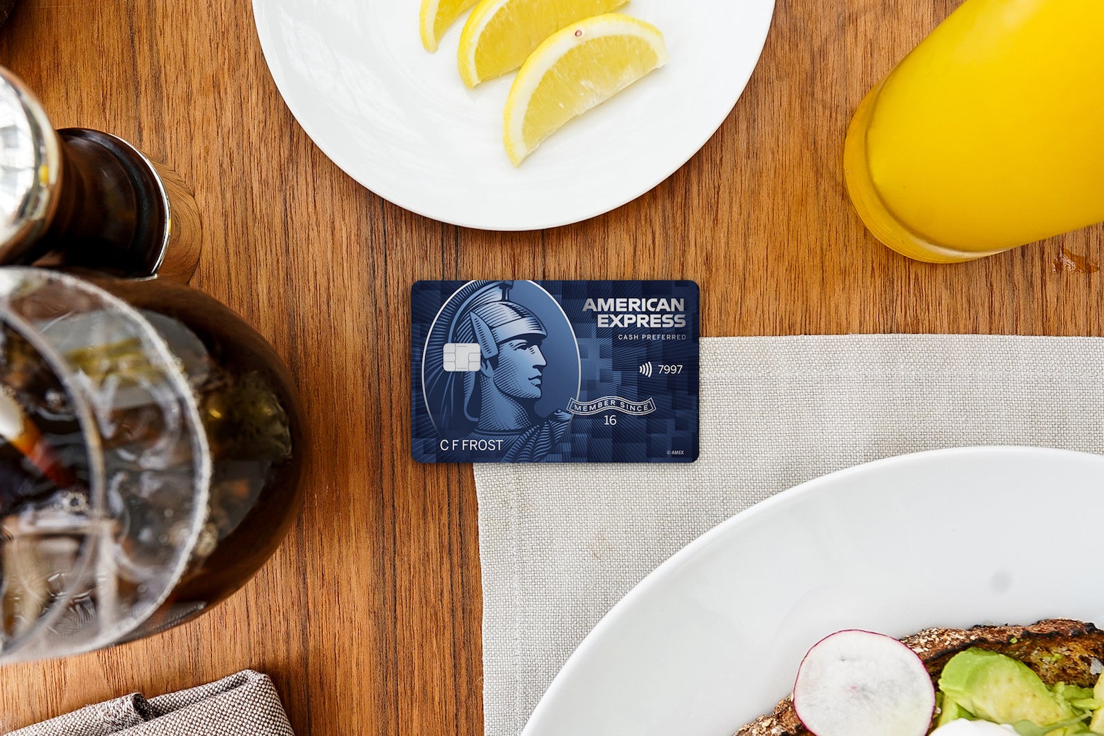 A credit card sits on a table surrounded by food and drink dishes