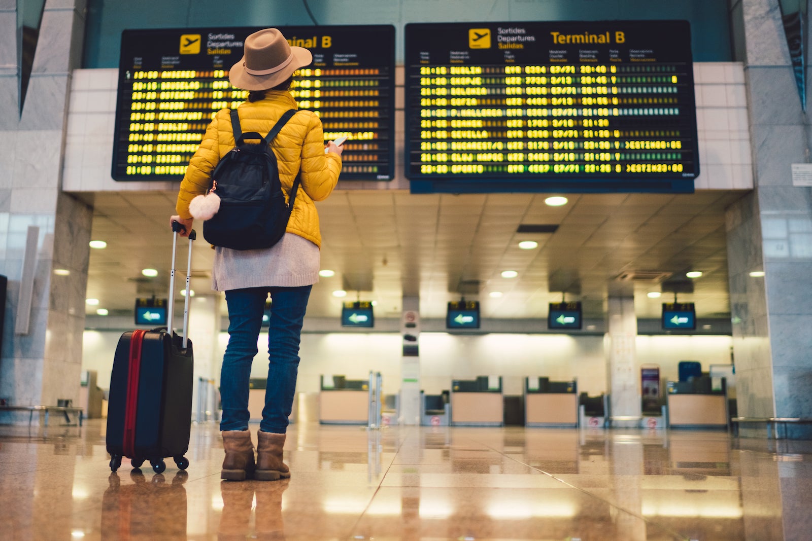 Female tourist with bag waiting airport flight stats