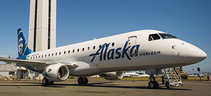 A Horizon Air Embraer E175 jet painted in Alaska Airlines colors sits near the control tower at Paine Field in Everett, Washington. (Courtesy of Alaska Airlines)