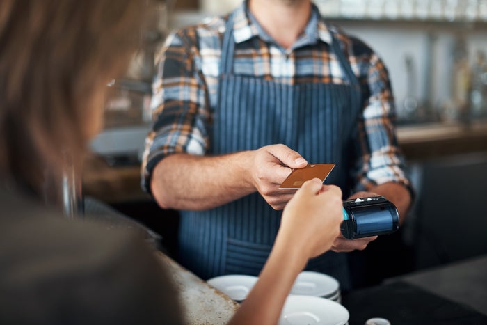 Closeup shot of a unrecognizable person giving a barman a credit card as payment inside of a restaurant(Photo by shapecharge/Getty Images)