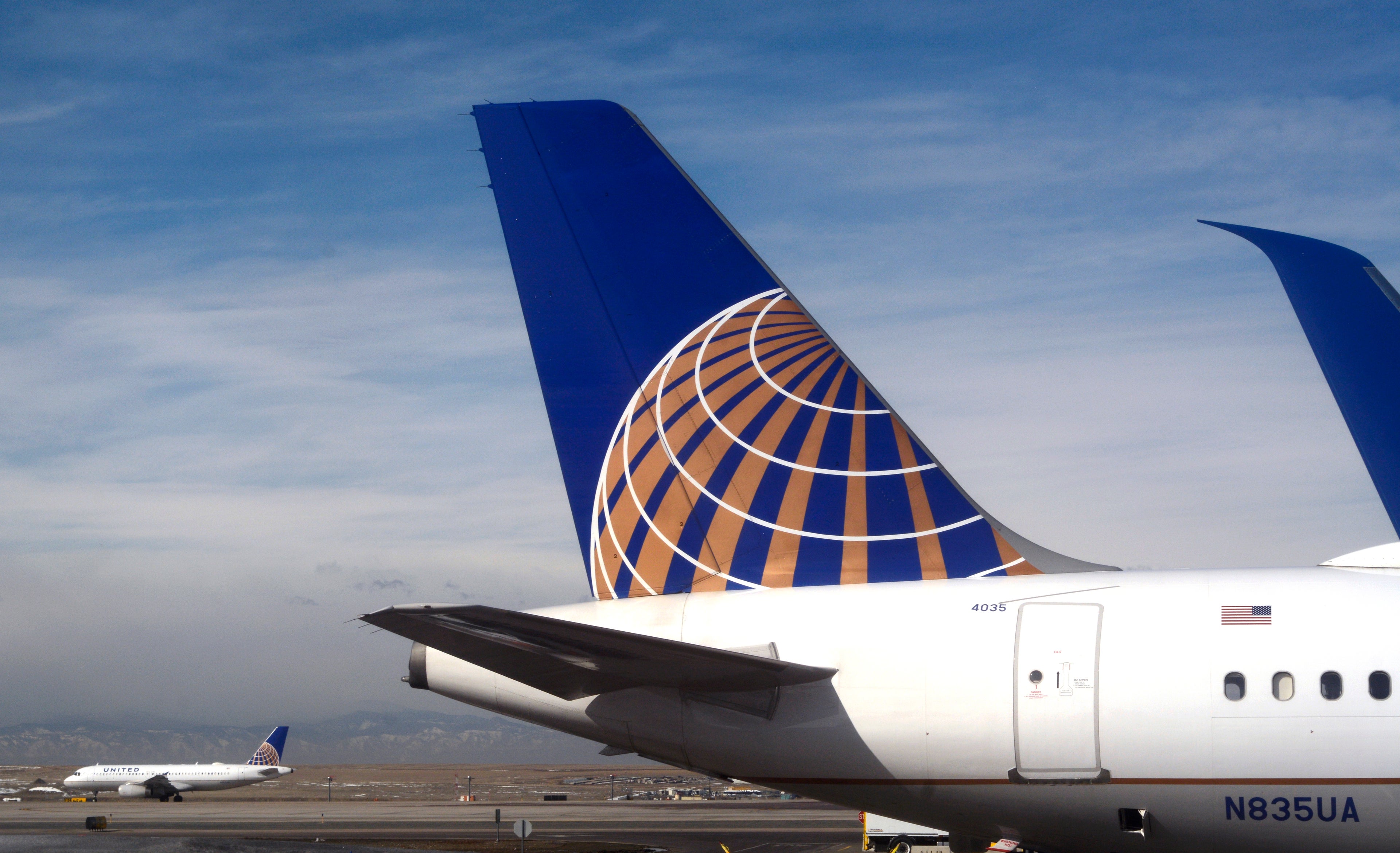 A United Airlines jet taxis as another sits at a a gate at the Denver International Airport.