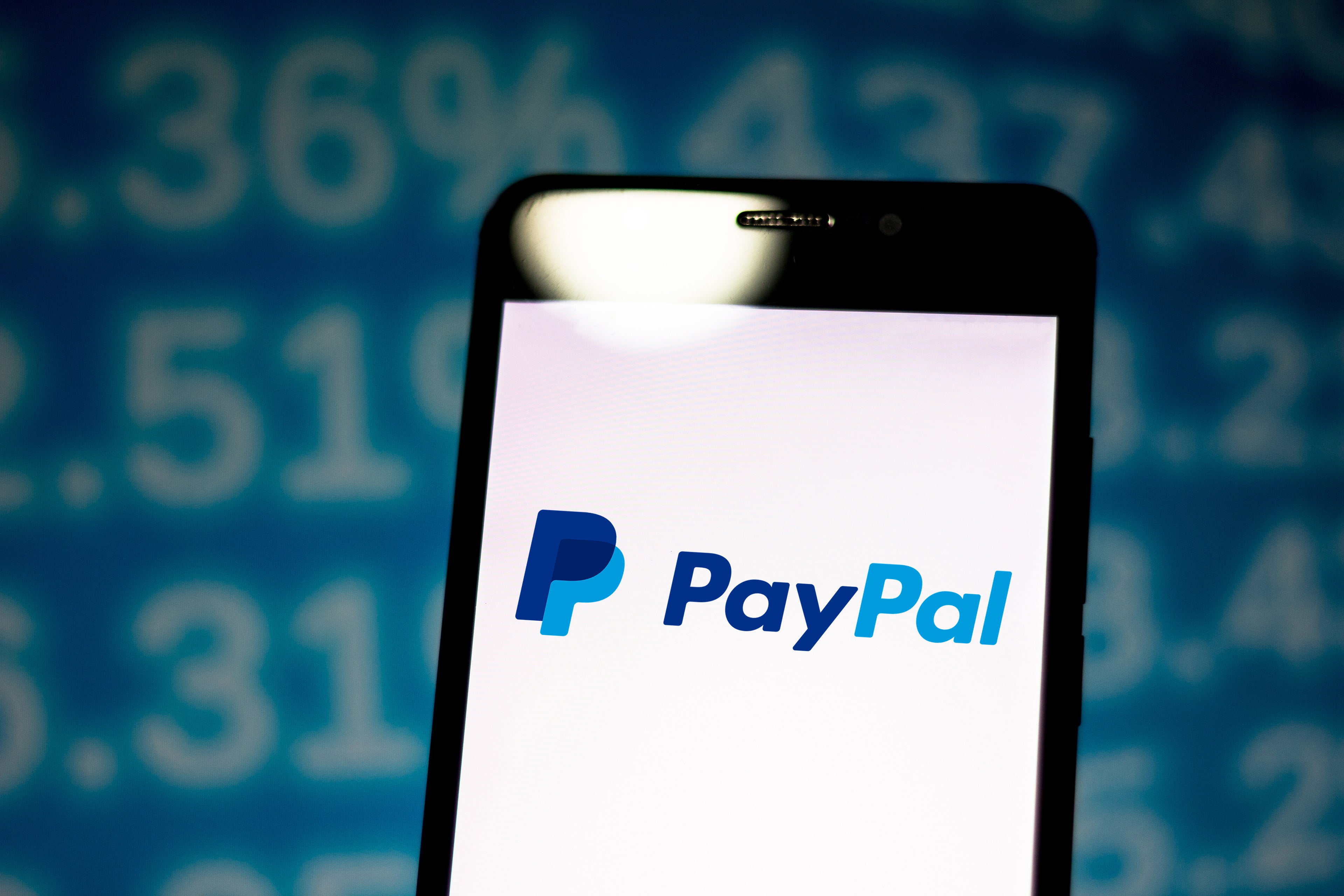 In this photo illustration the PayPal logo is seen displayed