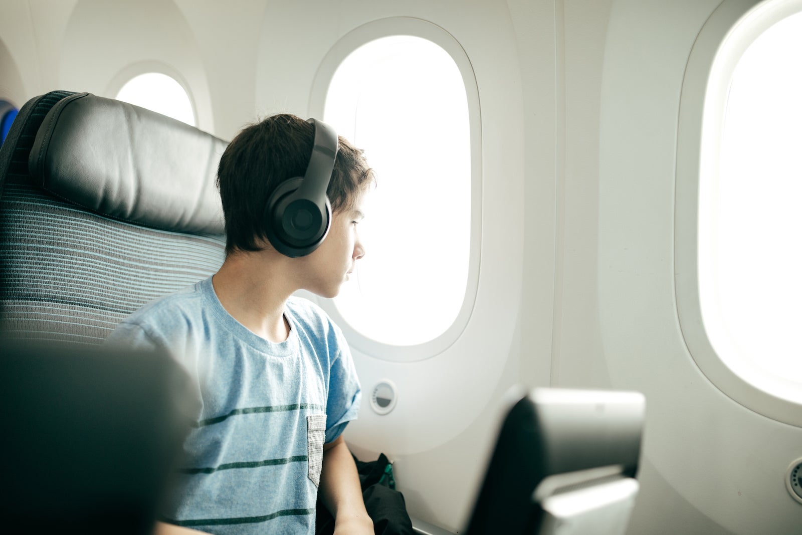 Boy alone plane headphones