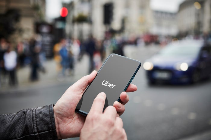 LONDON, UNITED KINGDOM - JUNE 4: Detail of a man holding up an Honor 20 Pro smartphone with the Uber transport app visible on screen, while taxis queue in the background, on June 4, 2019. (Photo by Olly Curtis/Future Publishing via Getty Images)