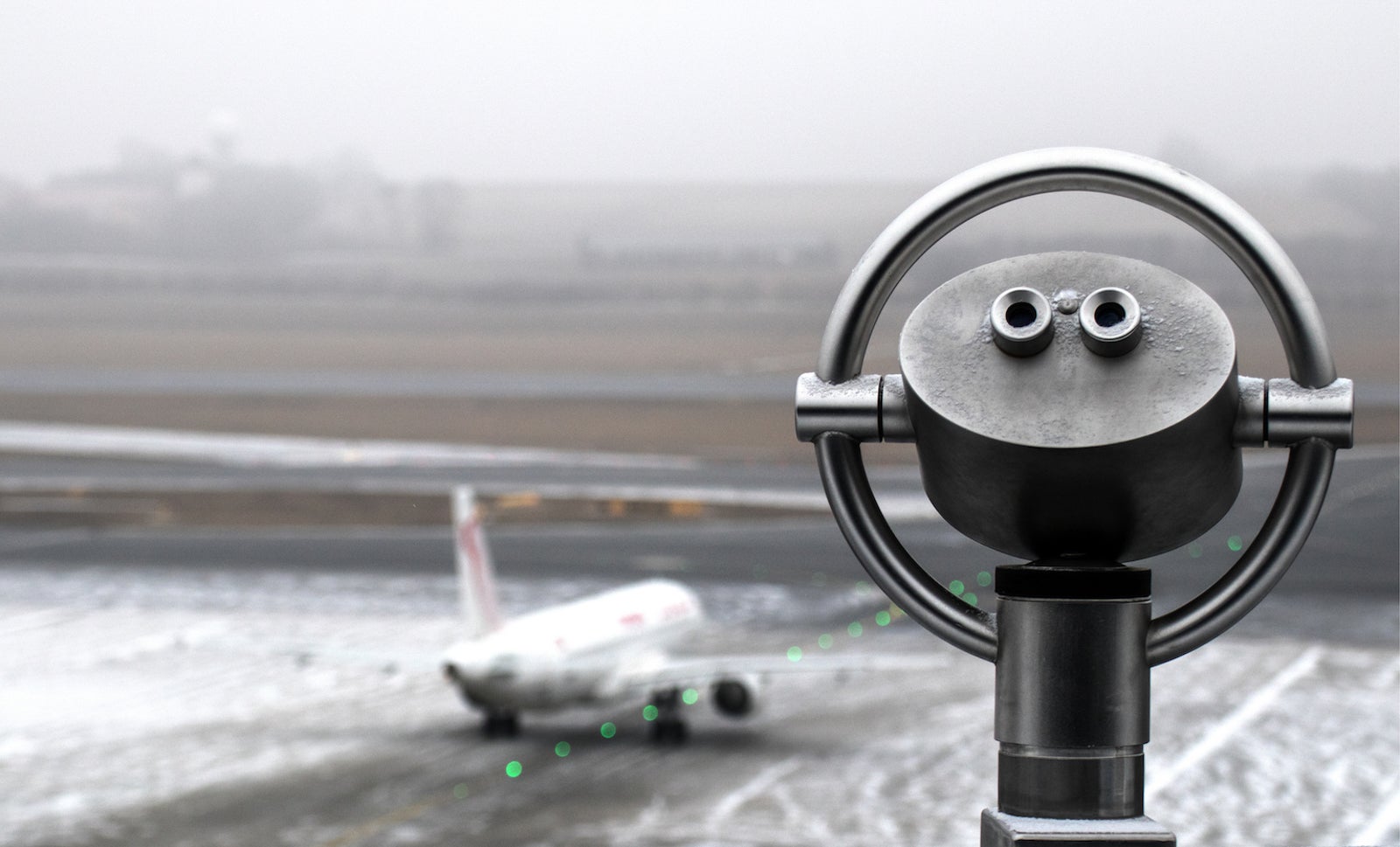 Close-Up Of Coin-Operated Binoculars Against Airport Runway
