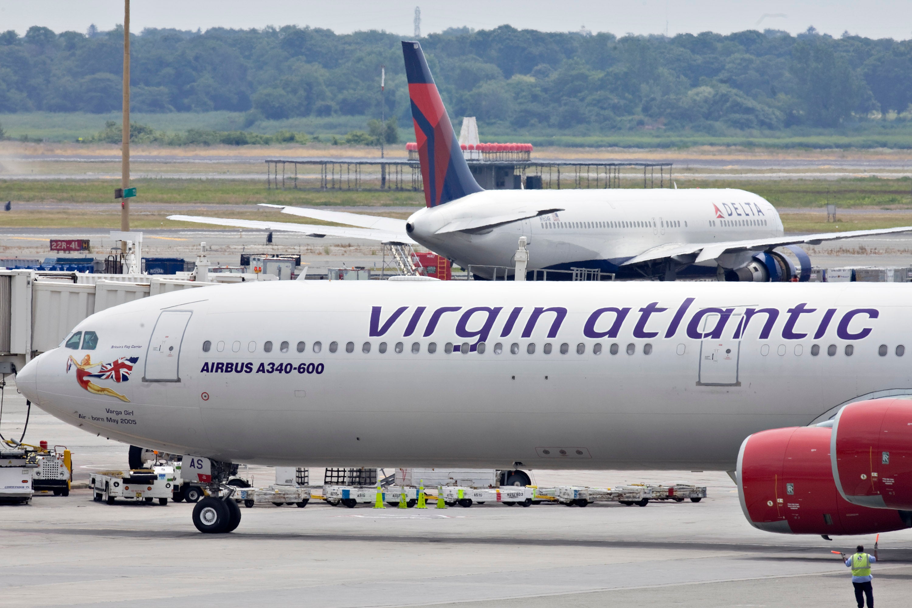 A Virgin Atlantic plane taxis past a Delta plane at John F.