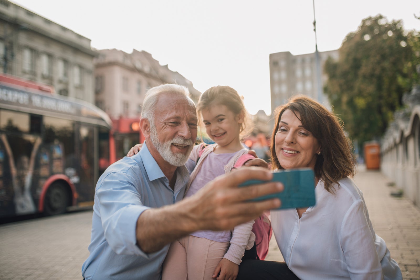 Happy older couple taking a selfie with granddaughter