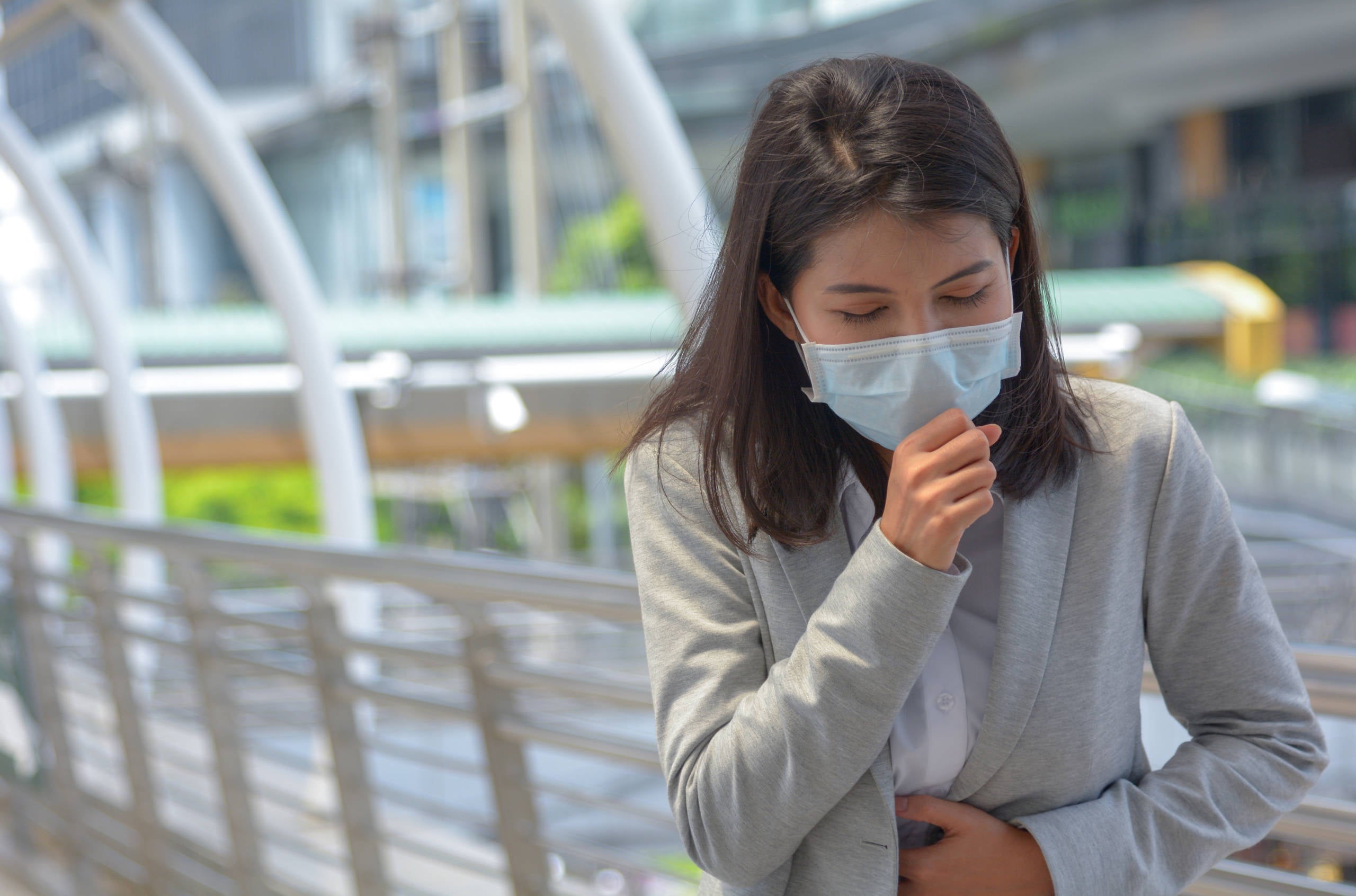 Young woman wearing mask and feeling sick