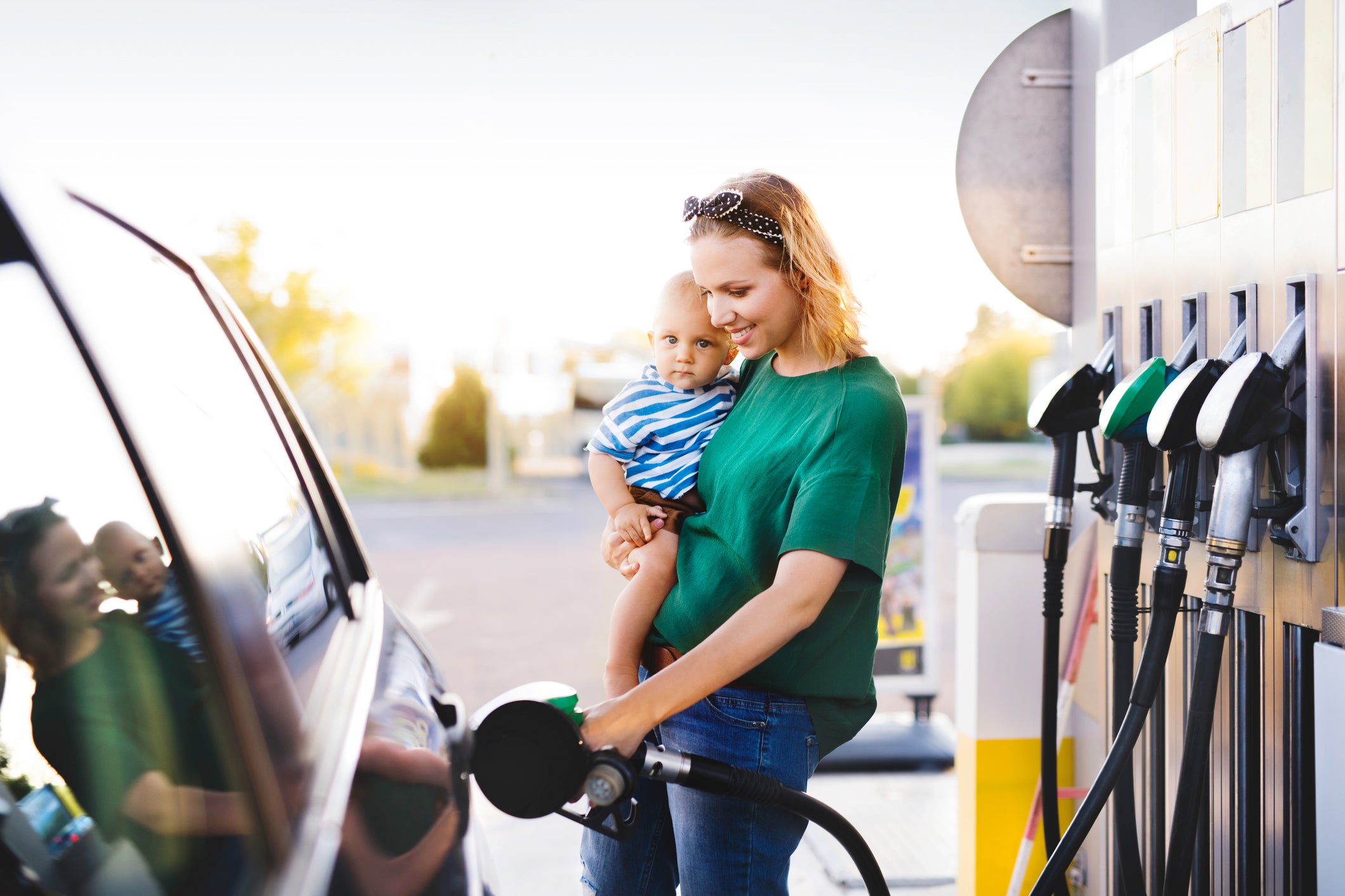 mother and baby at gas pump