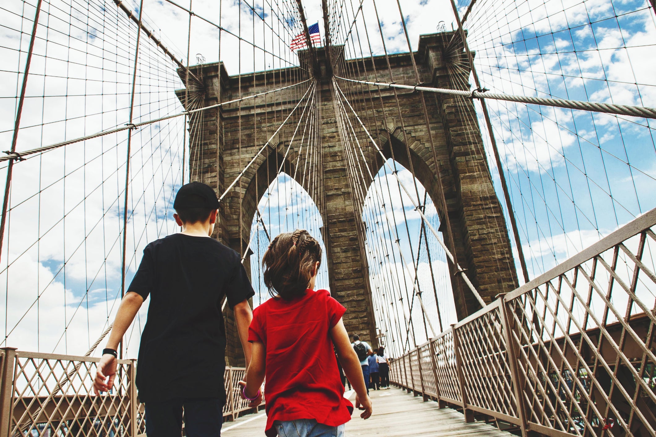 Rear View Of Brother And Sister Walking On Brooklyn Bridge