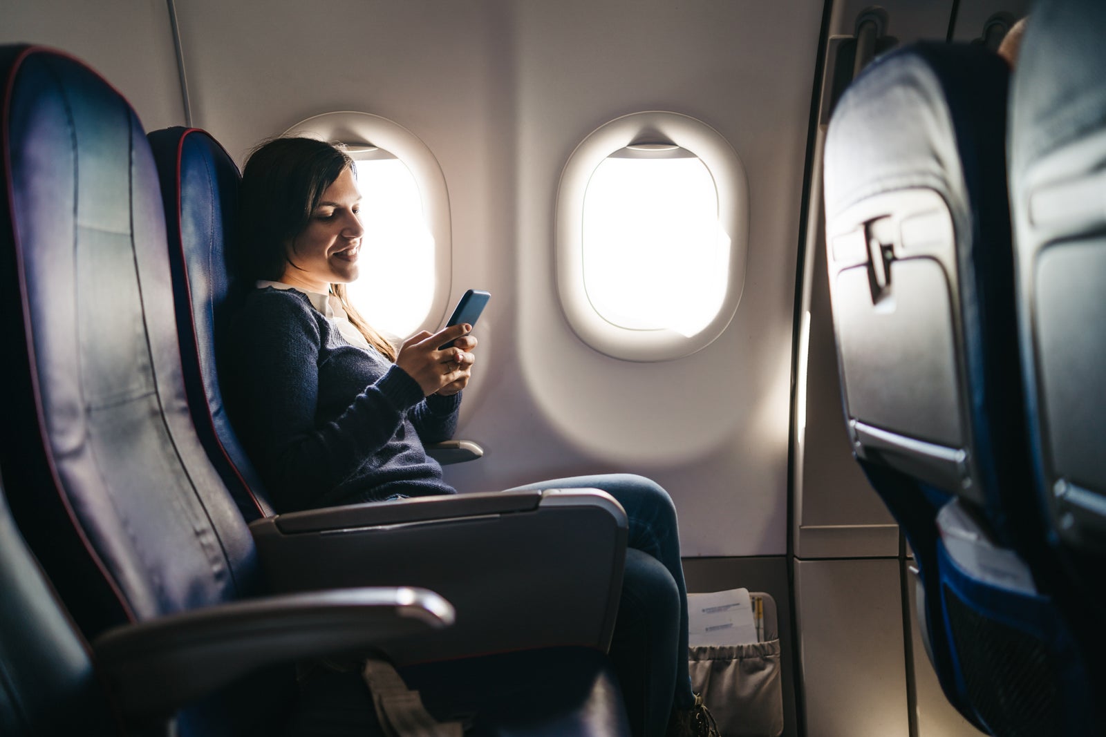 woman using phone on plane