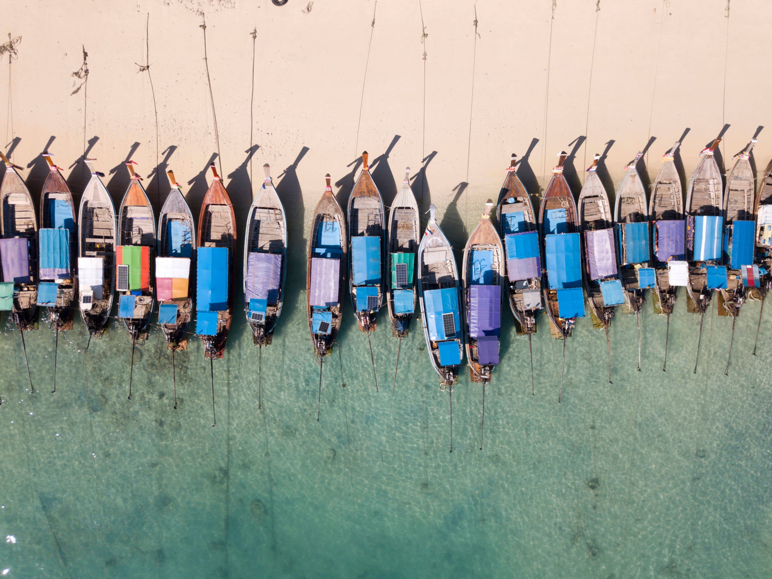 Aerial view of long tail boats parked on beach