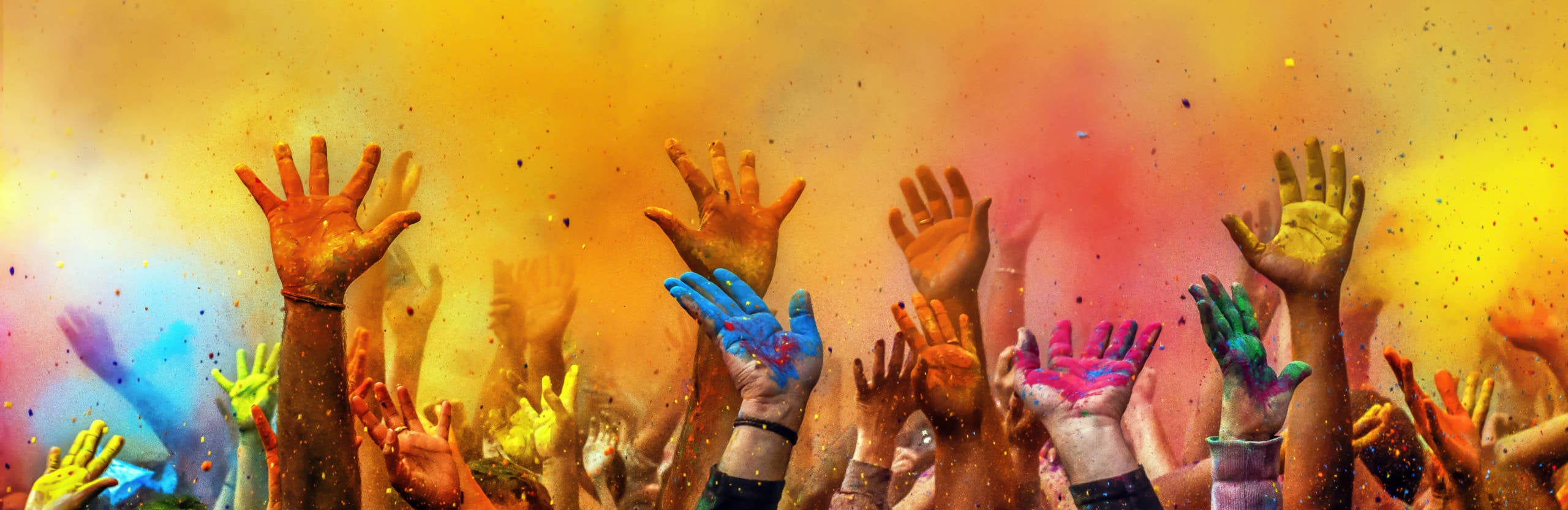 Hands painted with different colors raised up on Holi festival, Washington DC, USA