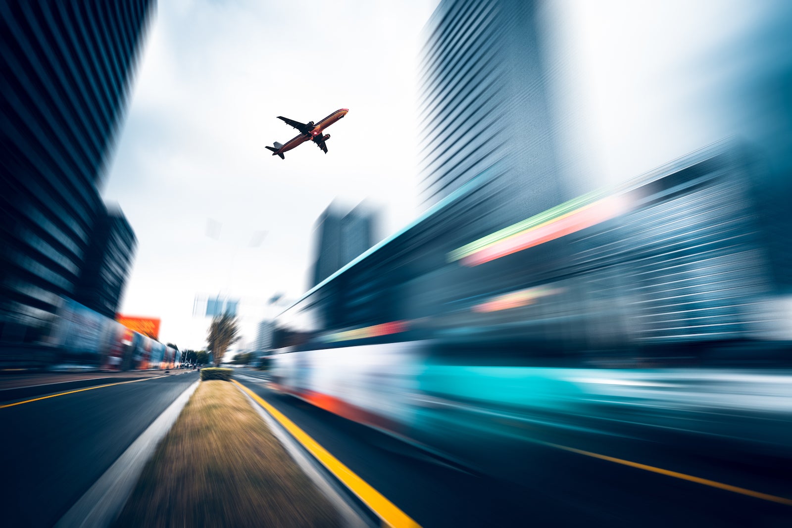 low angle view of a commercial plane flying over urban road