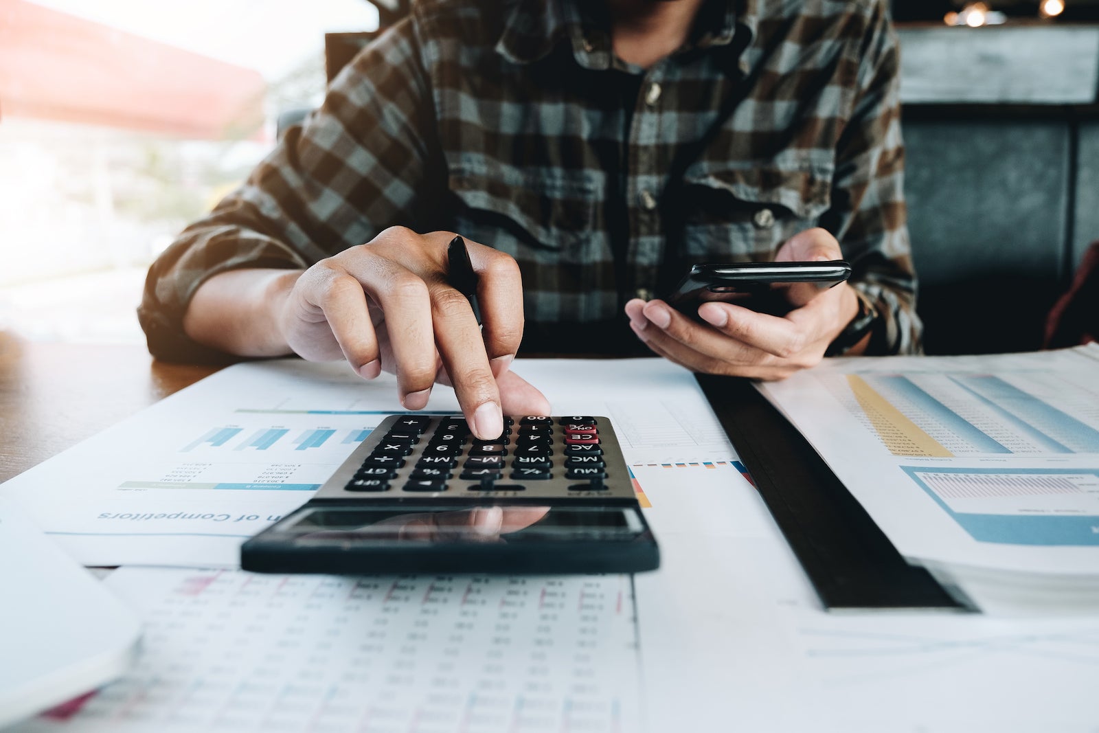 Man using a calculator while working on finances