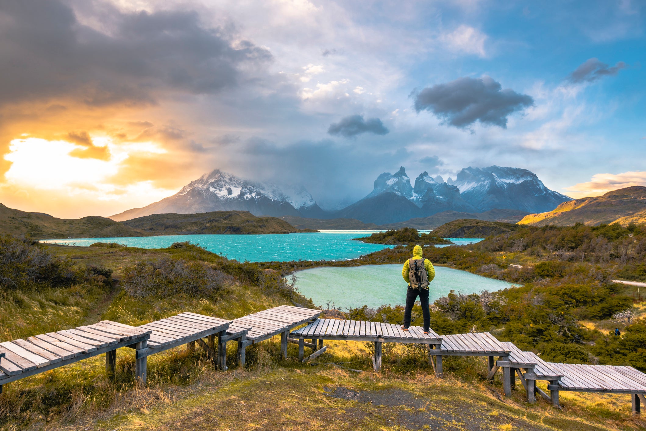 Tourist admiring the lake Pehoe and Torres del Paine range at sunset, Chile