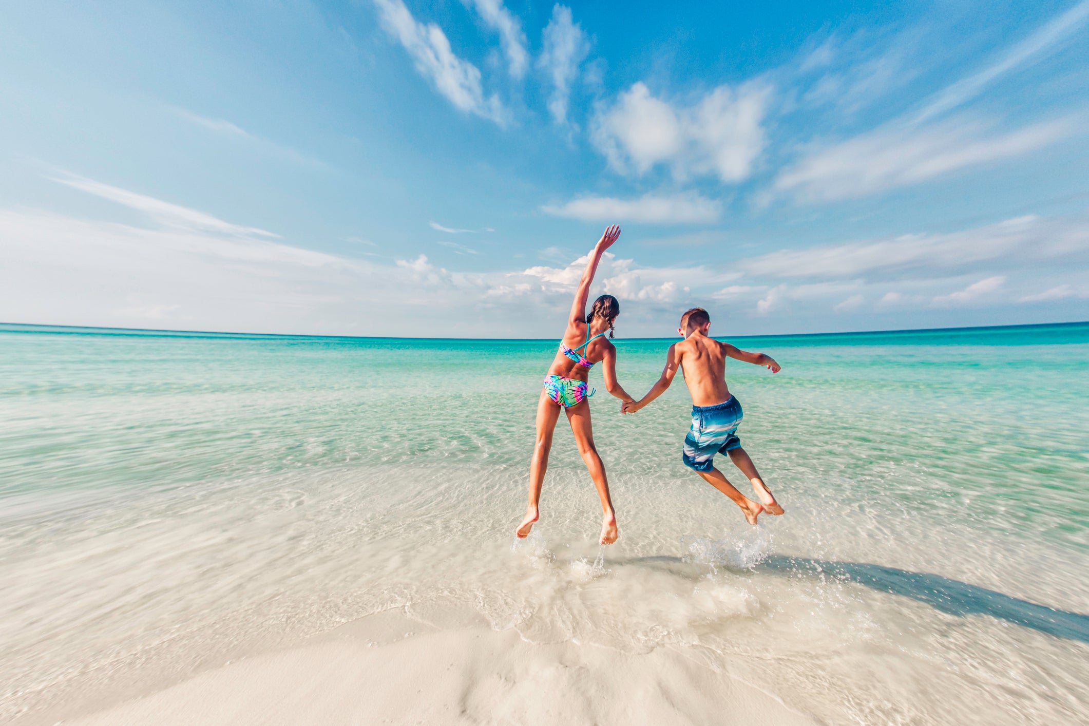 boy and girl jumping in the surf of the Gulf of Mexico